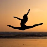 Silhouette of woman doing a split jump